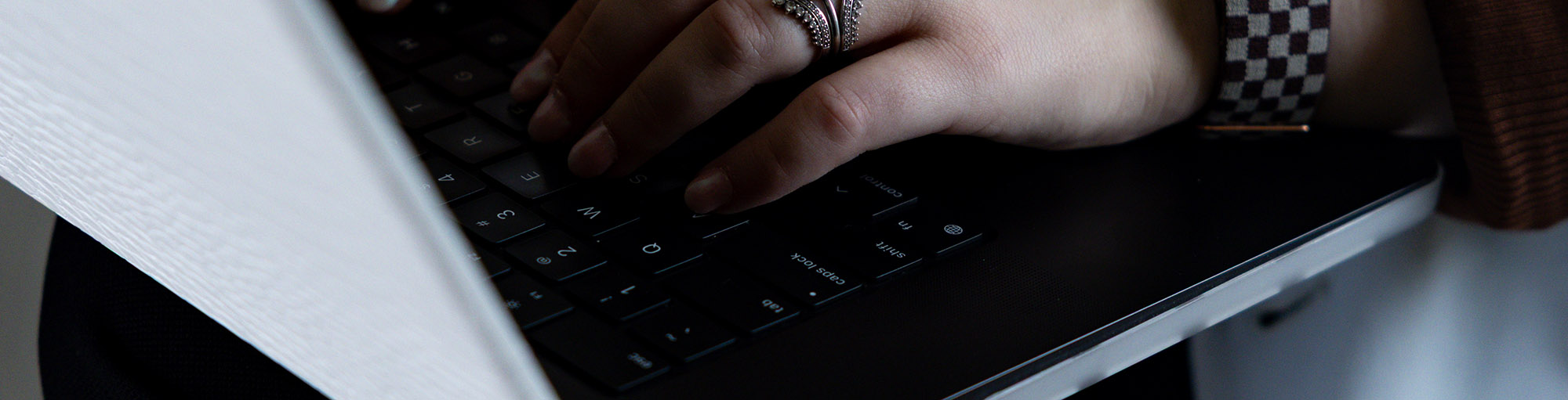 Close up of hands typing on laptop keyboard.